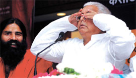 Railway minister Laloo Prasad does yoga while yoga guru Ramdev looks on during a book release function in the Capital on Tuesday.