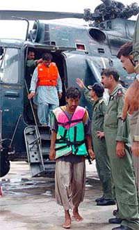 Pakistani fishermen step down from a helicopter as they arrive at a military base in Karachi