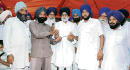 SAD executive member Randhir Singh Bhambri distributes cheques for developments at Ladpur village on Wednesday.