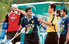 Indias Dilip Tirkey (centre) argues with umpire Dekanf Chen over his decision on a penalty corner in the match against Argentina at the Champions Challenge hockey tournament in Antwerp