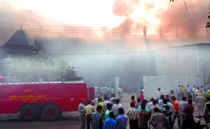 People gather outside a factory at Sector 1 in Noida. The factory was gutted on Friday morning.