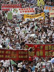 Pro-democracy protesters carry banners demanding universal suffrage during a march in Hong Kong on Sunday, marking the 10th anniversary of Hong Kong's handover to Chinese rule.