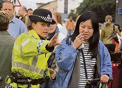 A police officer gives directions to a passenger outside Glasgow airport which was partially reopened on Sunday.