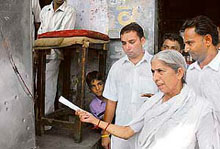 Health minister Luxmi Kanta Chawla points towards the bullet marks in a shop in Fatehabad town after a recent attack of the Cobra gang. 