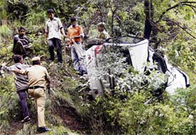Residents and police personnel carry out rescue operations after a car fell down the hill near Himachal Holiday Home in Shimla on Tuesday.