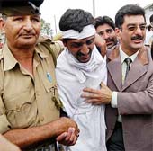 A jobless electropathy graduate (centre), is helped by police officers in Srinagar on Tuesday.