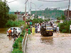 Cycles and rickshaw-pullers find it difficult to wade through a flooded road in Bathinda