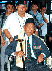 Former Gurkha soldier in the British army Tul Bahadur Pun (foreground) is wheeled towards the airport lounge in Kathmandu on Tuesday prior to his departure for Britain.