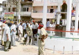 Employees of the Municipal Council remove iron bars from the vicinity of a roundabout at the Dhulkot Chowk at Mandi Ahmedgarh on Tuesday.