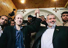 British Broadcasting Corporation (BBC) reporter Alan Johnston (front left) and former Palestinian Prime Minister Ismail Haniyeh of Hamas raise their hands following Johnstons release in Gaza City on Wednesday. Johnston was released after nearly four months in captivity in the Gaza Strip. 