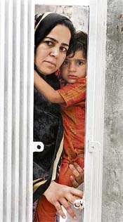 A resident of Islamabad looks through a gate as the Pakistan army imposed curfew near Lal Masjid on Friday. 