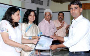 Parliamentary secretary, Labour and Employment, Sharda Rathore presents a visa to Ashok Kumar of Hisar, student of hotel management, at a function at Karnal on Saturday.