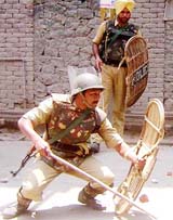 A CRPF jawan tries to save himself from the stones hurled by protesters during a demonstration in Srinagar