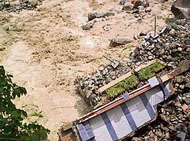 A part of a three-storey building in the housing board colony, Dharamsala, washed away in a flash flood in the Manooni rivulet caused by a cloudburst in the Dhauladhar ranges on Sunday morning