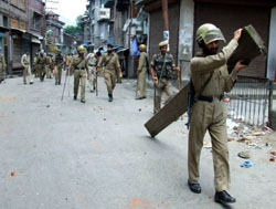 Policemen patrol on a street during a protest in downtown Srinagar on Monday. Angry demonstrations were held on Monday for the fourth consecutive day to protest a youths killing in police firing. 
