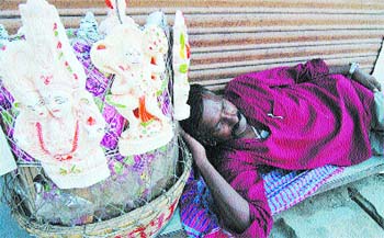 A vendor selling idols catches a wink on a hot Tuesday afternoon in Amritsar