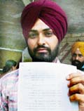Gurmel Singh shows the documents of the village land allegedly grabbed with the help of sarpanch.