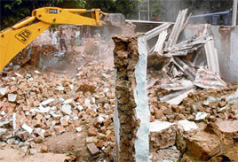 A structure being pulled down in the Sector 25 Kumhar Colony on Thursday.