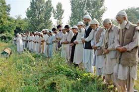 Villagers offer prayers for a person whose body was retrieved from Jhelum, at Baramula