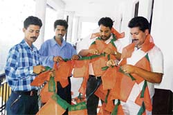BJP workers give final touches to the party flags for the executive committee meeting starting in Dharamsala on Saturday.