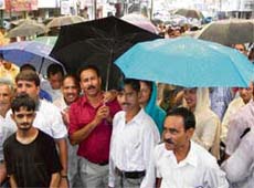 These BJP activists brave rain to participate in a demonstration in protest against price hike in Hamirpur on Friday.