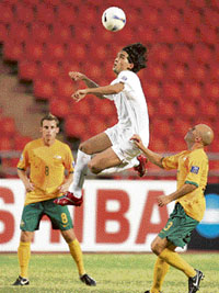 Australians players Mark Bresciano (R) and Luke Wilkshire (L) look on as Iraqi midfielder Nashat Akram jumps to head a ball during group A match of the Asian Cup 2007 football tournament at Ratchamangla Stadium in Bangkok on Friday. Iraq defeated Australia by 3-1