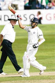 Sachin Tendulkar raises his bat on completing his hundred during the second day of the three-day match against England Lions in Chelmsford