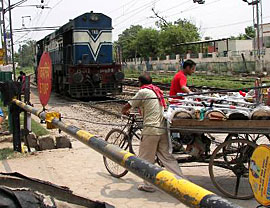 People walk through a railway crossing, unmindful of a train coming towards them, in Ambala on Sunday. 
