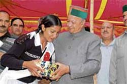 Chief Minister Virbhadra Singh honours a student of Chail Senior Secondary School, on Sunday. 