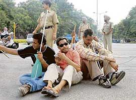 Members of the National Federation of Blind block traffic at the press lights on the road dividing Sectors 9 and 17 in Chandigarh on Monday.