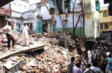 Residents look for their belongings in the debris of the house that collapsed on Monday, killing three persons at Chandni Chowk in the Capital on Monday. 
