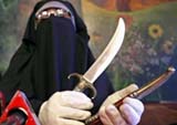 Syeda Aasia Indrabi, chief of the banned organisation Dukhtaran-e-Millat, displays daggers during a press conference in Srinagar