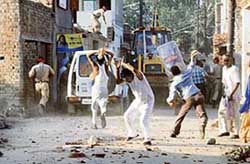 Residents of the Dhapai Road locality throw stones at the police and municipal corporation staff in Amritsar on Tuesday. 