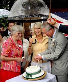 Britains Duchess of Cornwall Camilla (centre) smiles as Prince Charles lights candles on her birthday cake during a visit to the village of Bromham, England, on Tuesday. The visit coincides with the Duchesss 60th birthday.
