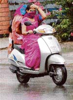A scooterist caught in the rain in Chandigarh on Friday afternoon