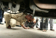 A policeman inspecting a Blueline bus at I P Depot in the Capital