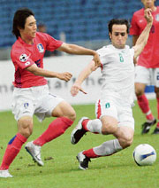 South Korea's Kim Chi-woo (L) and Irans Ali Karimi vie for the ball during the Asian Cup quarterfinals in Kuala Lumpur on Sunday.