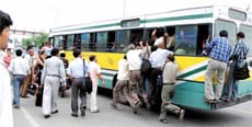 Commuters make a desperate bid to board a bus at ITO in the Capital on Monday