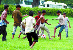 Children sweat it out in the sultry weather on a green of the India Gate in the Capital on Tuesday.