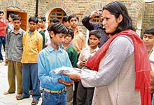 Department of Social Justice and Empowerment director Anuradha Thakur distributes clothes among street children at the Sadar police station in Shimla on Wednesday.  Tribune photo by S.Chandan
