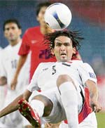 Iraq's Nashat Akram leaps in the air to clear the ball against South Korea during the Asian Football Cup 2007 semi-finals in Kuala Lumpur