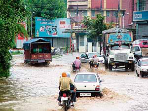 Owing to poor drainage, vehicles have a harrowing time negotiating the water-logged national highway at Gutkar, near Mandi, following a downpour on Thursday morning.