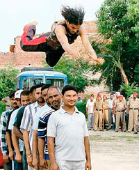 A police commando does a stunt during a demonstration on how to tackle mob organised by Punjab Police in Jalandhar