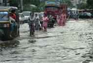 People wade through knee-deep water in Jalandhar on Friday