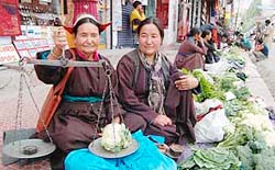 A Ladakhi mother and daughter, who are vegetable vendors, dressed in traditional Ladhaki attire.