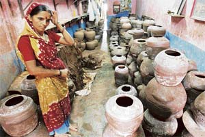 A potter looks at rows of earthen pots at a workshop in Dharavi. Plans for development of the slum have been opposed by the kumhars