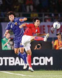 South Koreas Oh Beom-seok (right) and Japans Satoru Yamagishi fight for the ball during the bronze-medal match of the Asian Cup football tournament at the Jaka Baring stadium in Palembang, Indonesia