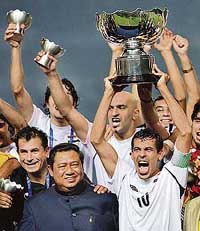 Iraqs captain Younis Mahmoud (right) holds the Asian Cup football trophy as Indonesian President Susilo Bambang Yudhoyono (second from left) looks on during the presentation ceremony at the Bung Karno Stadium in Jakarta on Sunday. Iraq beat Saudi Arabia 1-0 in the final.