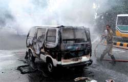 A fireman douses fire caught on a moving Maruti van at Imtiaz Khan Marg near Aakaashvani on Monday.