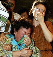Kim Kyong-Ja (right), mother of a woman kidnapped by the Taliban in Afghanistan, cries during a news conference which was called to give a statement signed by all family members in Seongnam, south of Seoul on Tuesday.